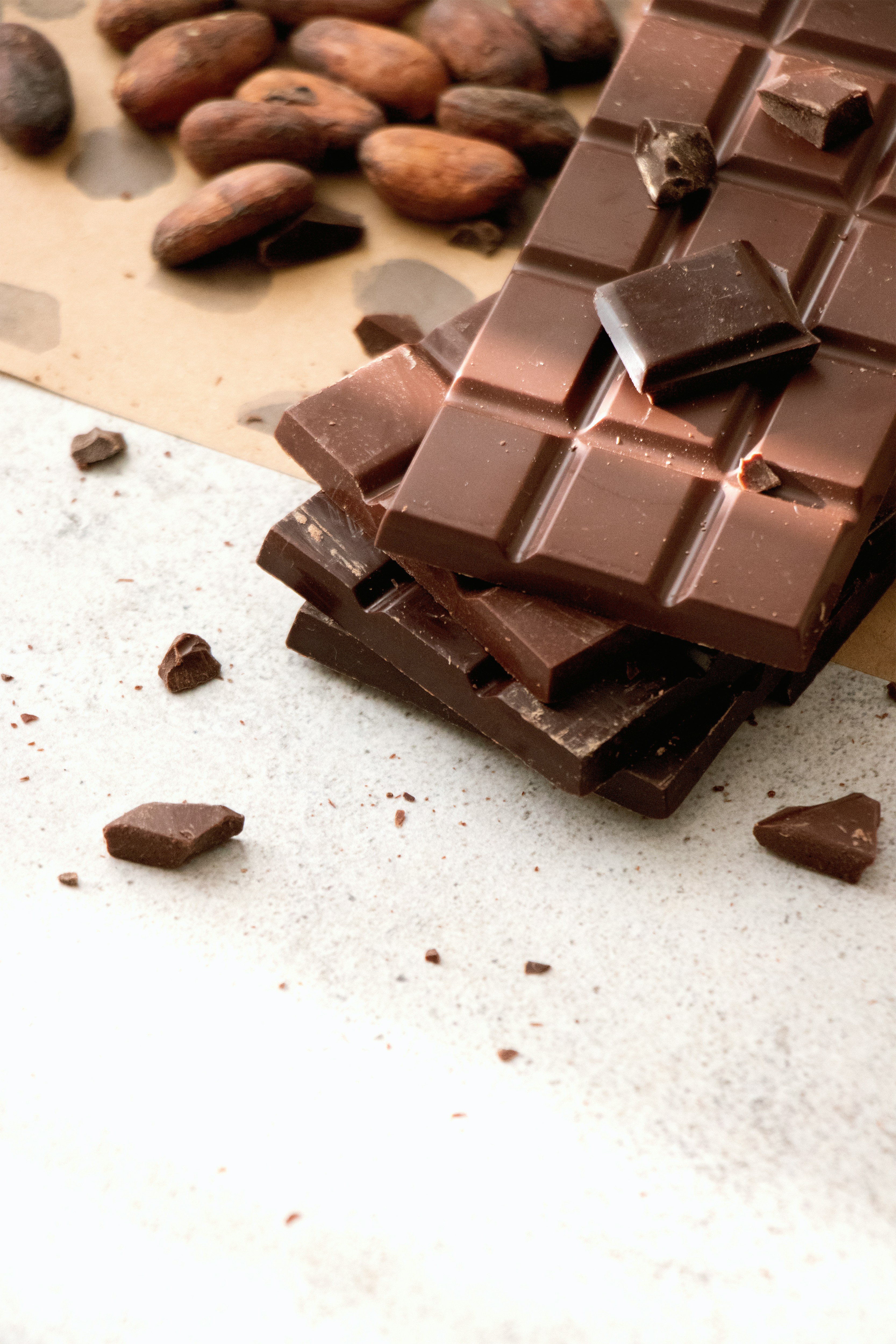 Stacked Hawaiian chocolate bars beside roasted cacao beans